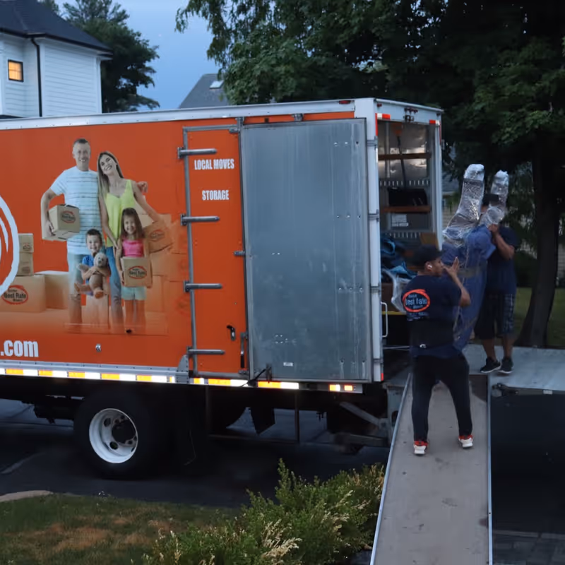 Boston Best Rate Movers crew loading wrapped furniture into truck