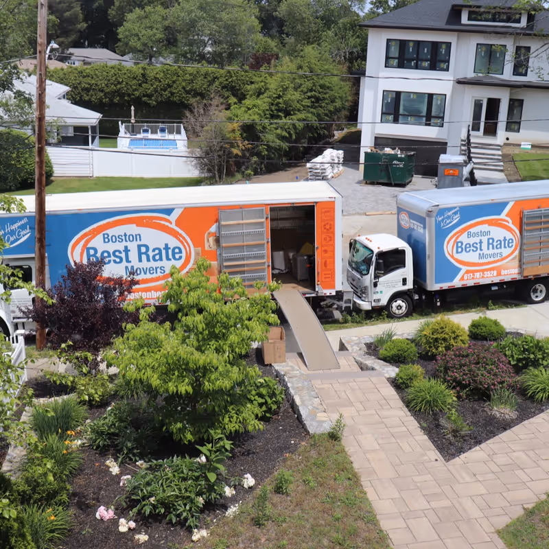 Two Boston Best Rate Movers trucks at a residential move, aerial view