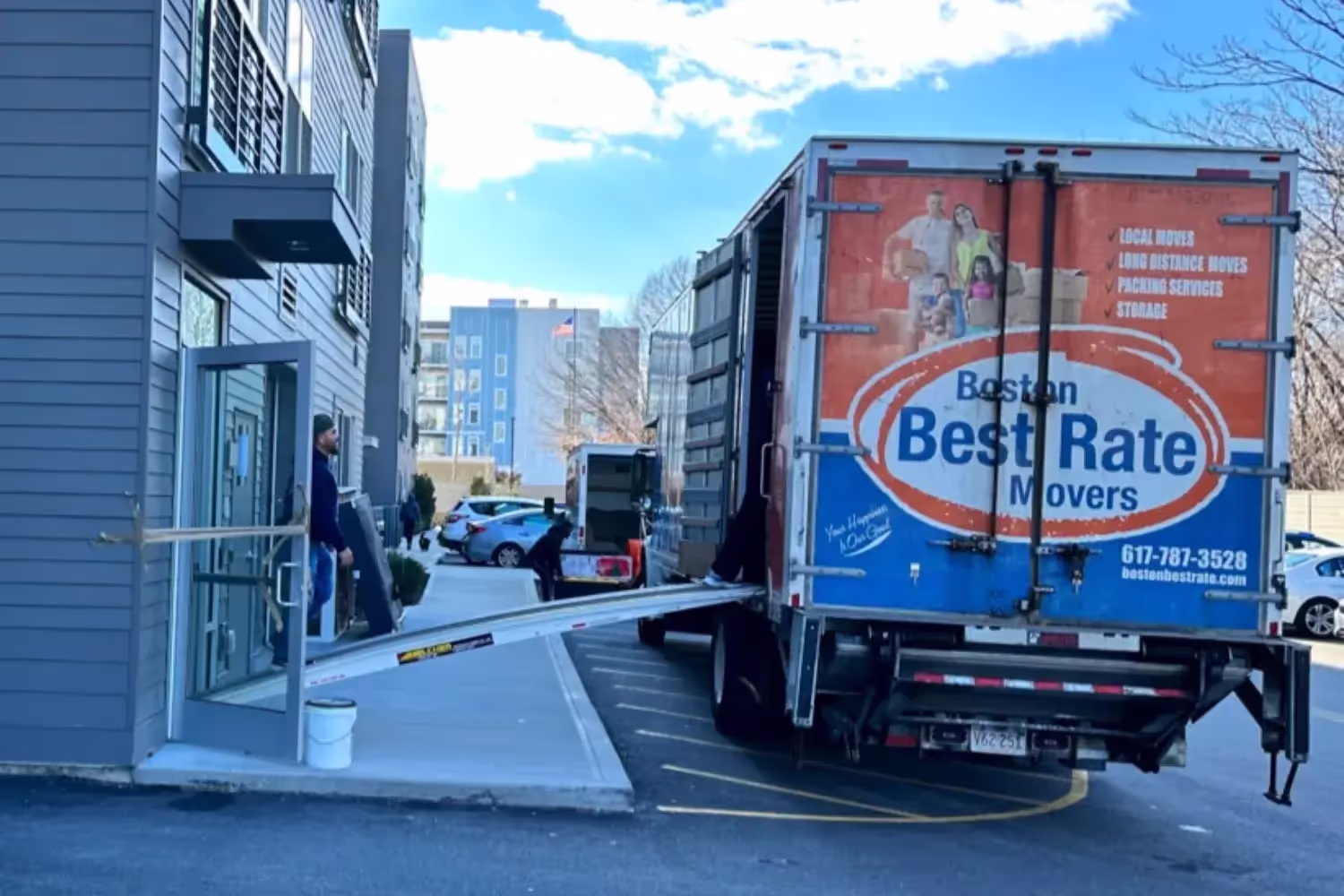 Apartment movers carrying boxes in a Boston walkup