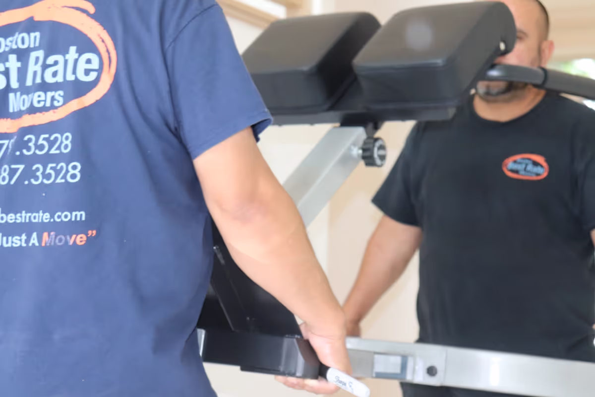Gym equipment movers handling heavy fitness machines
