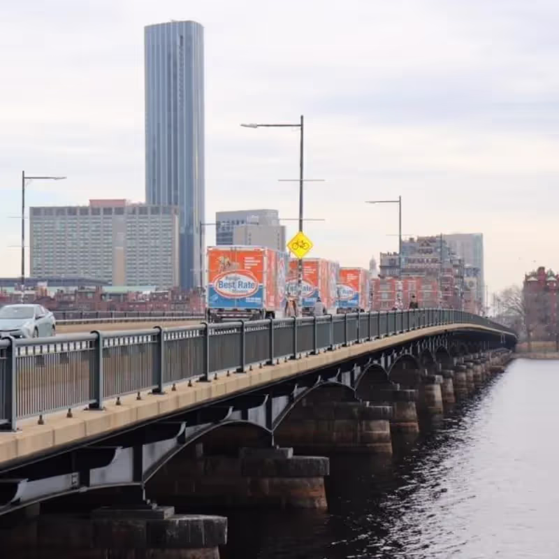 Boston movers carefully navigating furniture through doorway